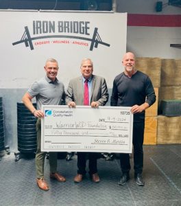 Three men standing behind a large check